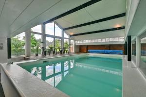 an indoor swimming pool in a house at Finest Retreats - The Warren at Conygre Farm in Pewsey
