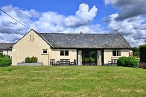 una casa blanca con dos bancos en un patio en Finest Retreats - The Burrow at Conygre Farm en Pewsey