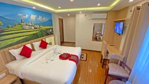 ein Hotelzimmer mit einem Bett mit einem Gemälde an der Wand in der Unterkunft Hotel Malati in Kathmandu