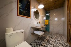 y baño con aseo, lavabo y espejo. en Hoi An Golden Bamboo An Bang Beach Villa & Spa, en Hoi An
