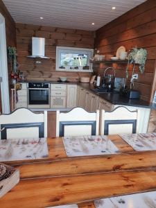 een keuken met een houten tafel met vier stoelen bij Småstranda Fjord Lodge in Åheim