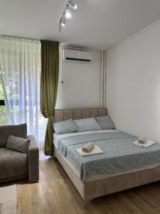 ein Schlafzimmer mit einem Bett und einem Sofa in der Unterkunft BeGreat in Belgrad