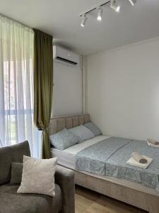 ein Schlafzimmer mit einem Bett, einem Stuhl und einem Fenster in der Unterkunft BeGreat in Belgrad