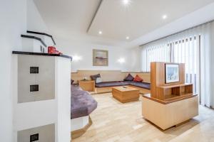 sala de estar con sofá y TV en Appartmenthaus DeKupi´s, en Sölden