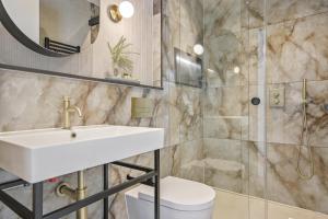 a bathroom with a sink and a shower at Bow Lane by Q Apartments in London