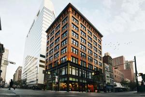 ein hohes Gebäude an der Ecke einer Stadtstraße in der Unterkunft Kinley Cincinnati Downtown, a Tribute Portfolio Hotel in Cincinnati