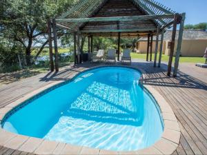 a swimming pool with a gazebo on a deck at Kayova River Lodge in Ndiyona
