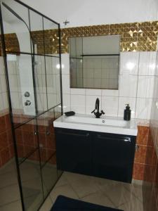 y baño con lavabo y ducha. en Villa Ambrosian (Haupthaus), en Trzebież