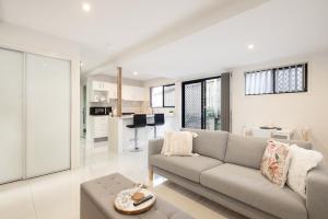 a living room with a couch and a table at Super Host! 2 bedrooms, Restaurants & Train in Brisbane