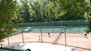 three people playing tennis on a tennis court at Neptun 501 in Balatonföldvár