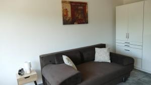 a living room with a brown couch and a chair at Neptun 501 in Balatonföldvár +4 photos