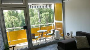 a living room with a balcony with a table and chairs at Neptun 501 in Balatonföldvár