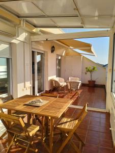 eine Terrasse mit einem Holztisch und Stühlen auf einer Terrasse in der Unterkunft Fabuloso Atico con vistas al mar in Carboneras