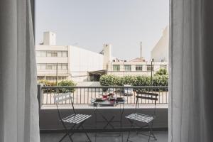 Ederlezi Habitat Apartments في بيرايوس: شرفة مع طاولة وكراسي على شرفة