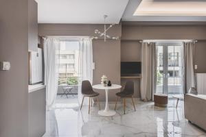 Ederlezi Habitat Apartments في بيرايوس: غرفة معيشة مع طاولة وكراسي بيضاء