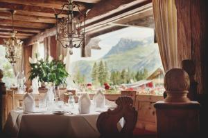 a dining room with a table with a mountain view at Burg Hotel Oberlech in Lech am Arlberg