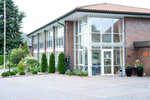 a large brick building with a large window at Hotel zur Post NEW STYLE in Garrel