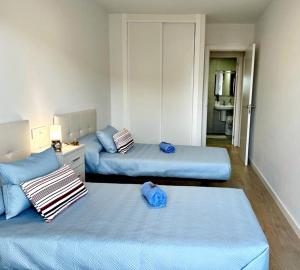 een kamer met 2 bedden en een woonkamer bij Holibai, Bon Xeito, Moderno y Cómodo Apartamento in Baiona