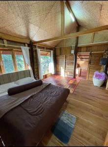 una grande camera con un letto in una baita di tronchi di PeaMoo Homestay a Chom Thong