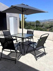 einen Tisch und Stühle mit Sonnenschirm auf einer Terrasse in der Unterkunft I Tre Soli casa vacanze in Lotzorai