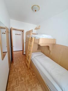 ein kleines Zimmer mit 2 Etagenbetten. in der Unterkunft Appartamenti Home Service in Arabba