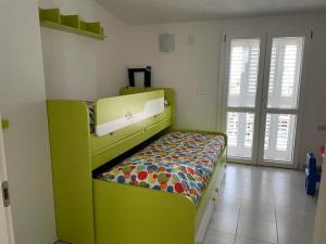 ein grünes Etagenbett in einem Zimmer mit Fenstern in der Unterkunft I Tre Soli casa vacanze in Lotzorai