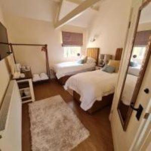 a hotel room with two beds and a mirror at Kings Head in North Lopham