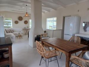 a kitchen and living room with a wooden table and chairs at Klein Paradys in Kleinmond
