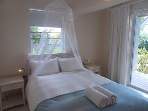 ein Schlafzimmer mit einem weißen Bett mit zwei Handtüchern darauf in der Unterkunft Klein Paradys in Kleinmond