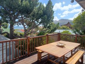 a wooden deck with a wooden table on it at Klein Paradys in Kleinmond