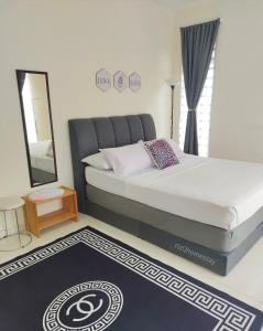 a bedroom with a bed with a mirror and a rug at RizQ Homestay Tg Malim in Kerling