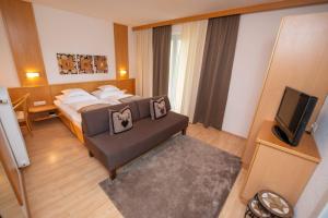 ヴァイセンゼーにあるArlbergerhof Vitalのベッドとテレビが備わるホテルルームです。