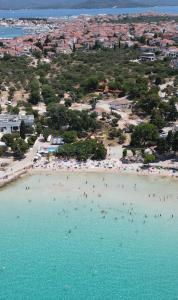 an aerial view of a beach with people in the water at Villa I Karma in Tisno