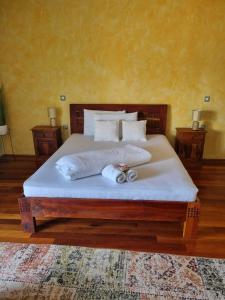 1 dormitorio con 1 cama con sábanas y almohadas blancas en Antik, en Strmec Samoborski