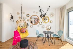 Zimmer mit einem Tisch, Stühlen und Spiegeln in der Unterkunft LivingTown in Zürich