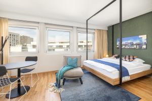 um quarto com uma cama, uma mesa e cadeiras em LivingTown em Zurique