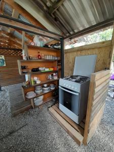 an outdoor kitchen with a stove in a house at Отель Домик у реки Хипста in Gudauta