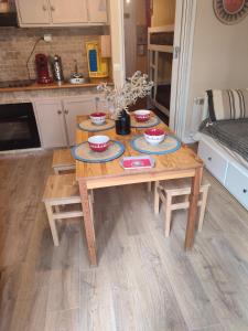 a wooden table with bowls and plates on it in a kitchen at studio 24M, cool les Orres 1650 in Les Orres