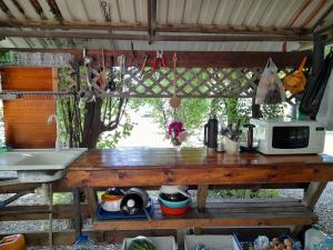 cocina con mesa de madera y microondas en Отель Домик у реки Хипста en Gudauta