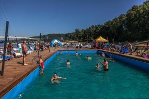 un grupo de personas en el agua en una piscina en SolinaGlamp, en Polańczyk
