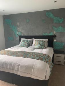 um quarto com uma cama grande e uma pintura na parede em The Brig & Barrel hotel em Buckie