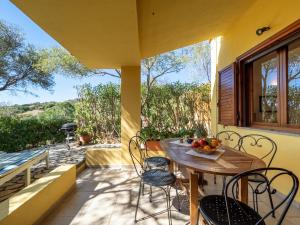 a patio with a table and chairs on a balcony at Casa Flaminia Villasimius in Villasimius