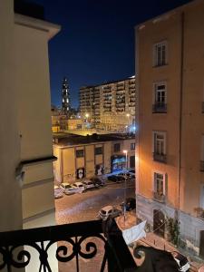 een balkon met uitzicht op de stad 's nachts bij Royal Dream in Napels