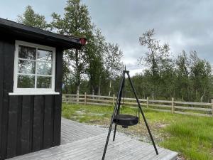 ein schwarzes Gebäude mit einem Eimer auf dem Deck in der Unterkunft Sigurdhytta in Ål