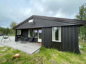 a black shed with a deck in a field at Sigurdhytta in Al
