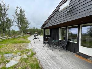 eine Holzterrasse mit Stühlen und einem Tisch auf einem Haus in der Unterkunft Sigurdhytta in Ål