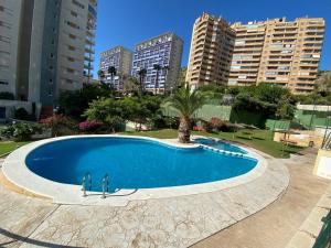 uma grande piscina numa cidade com edifícios altos em Apartamento Benidorm con piscina en la playa em Cala de Finestrat
