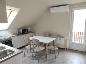 a kitchen with a table and chairs in a room at Egervári Béres Vendégház-Tetőtéri apartman in Egervár