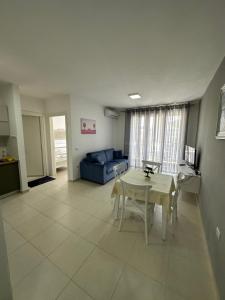 uma sala de estar com uma mesa e um sofá azul em Merville Apartment 6 em Durrës