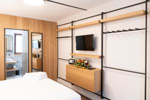 a bedroom with two bunk beds and a tv at Hotel SALEI in Ghigo